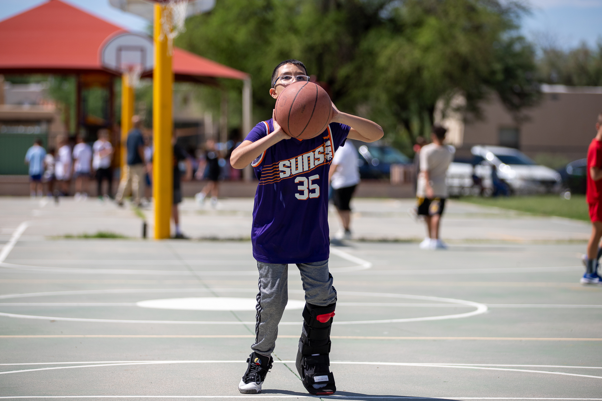 A boy shoots a basket on the first day of school