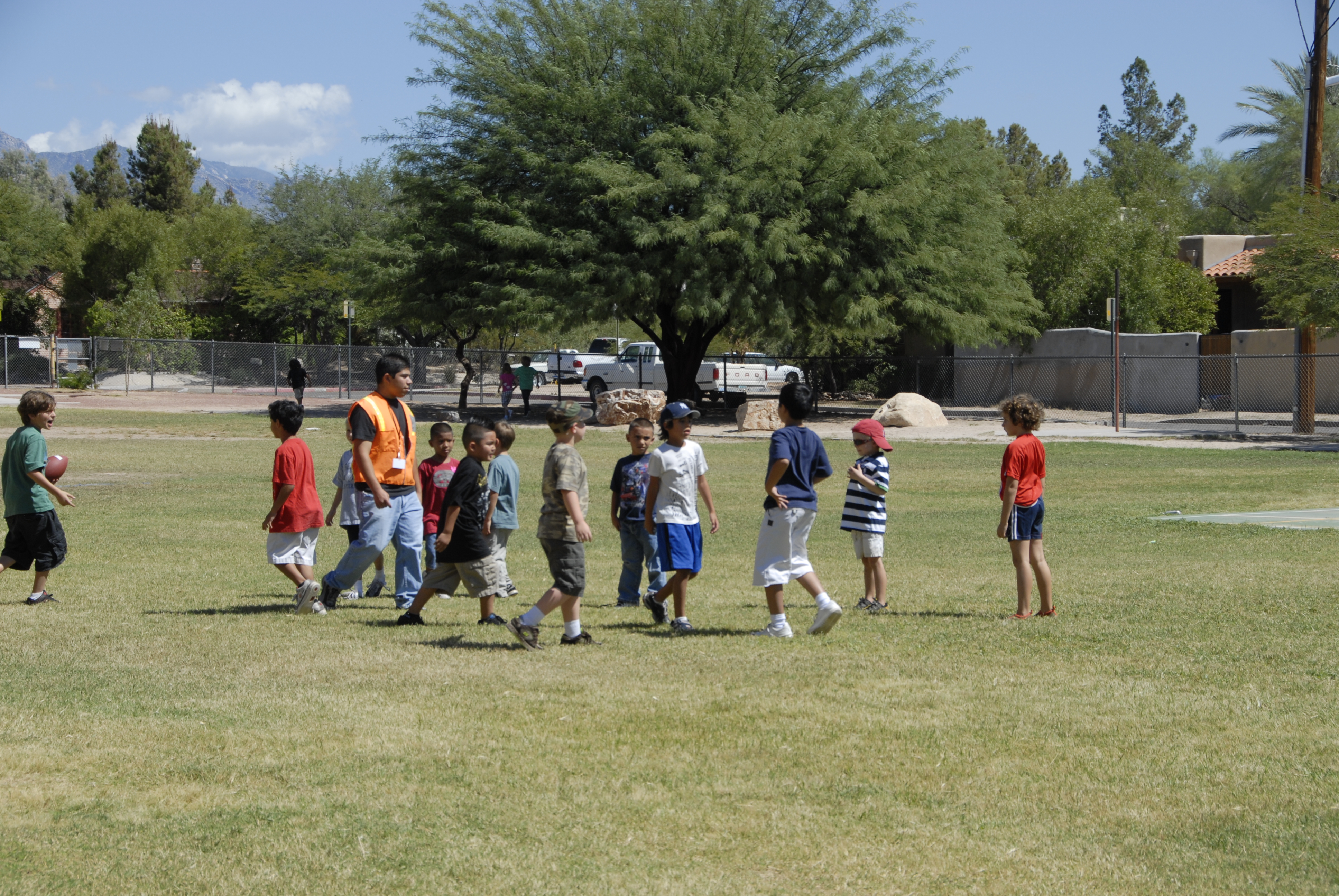 Students play a game of football on the school field